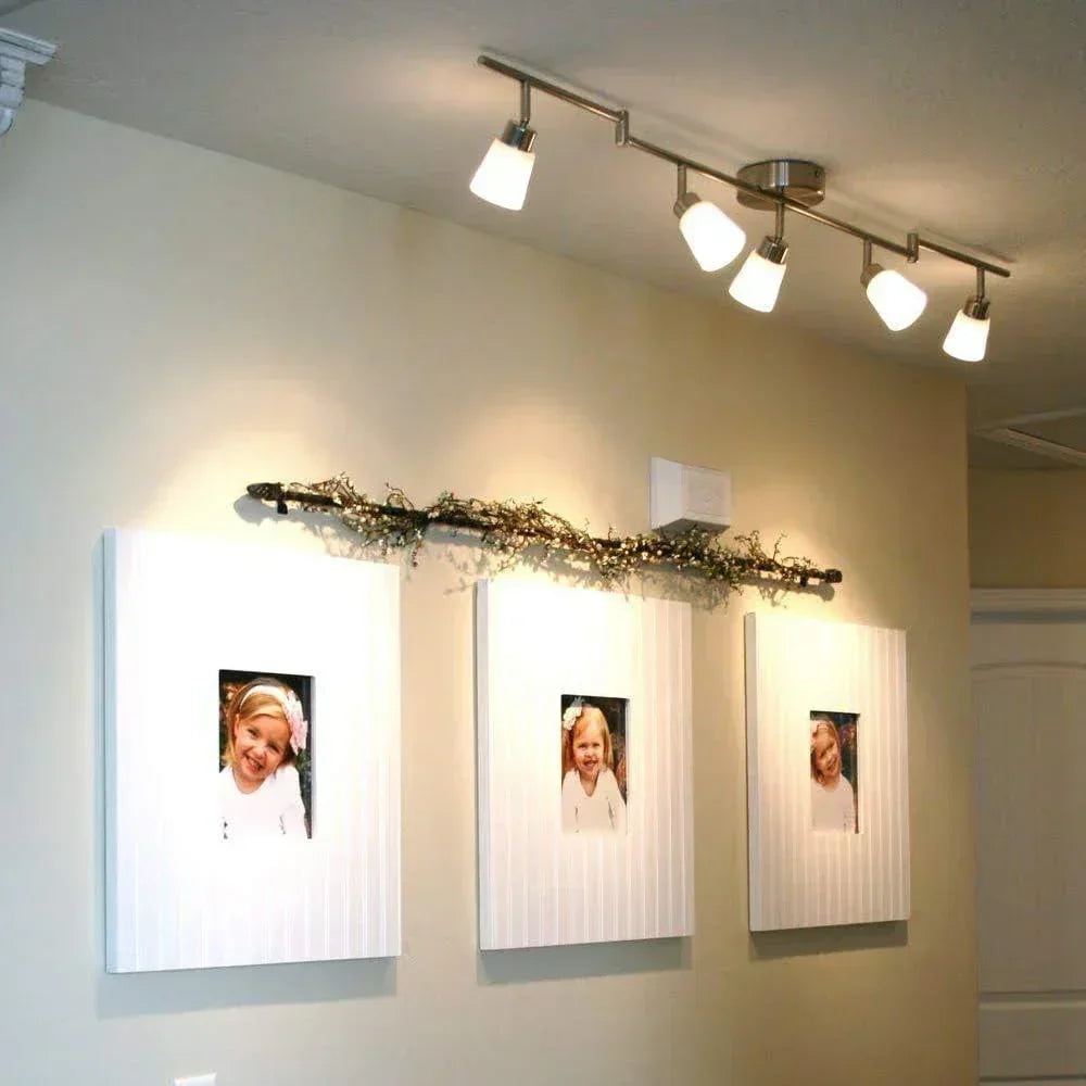 Modern LED ceiling track light illuminating a wall with framed photos in a hallway
