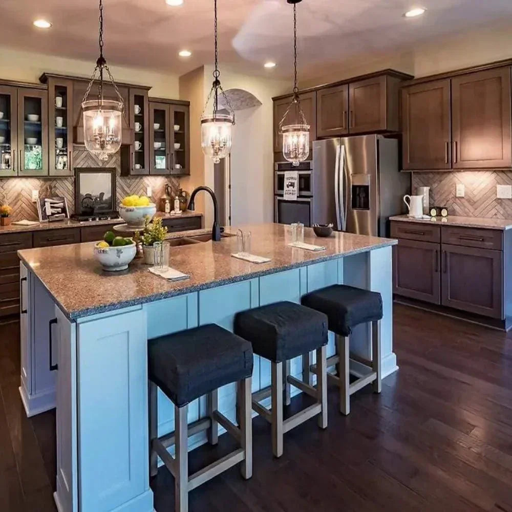 Modern kitchen with pendant LED ceiling lights, large island, and stainless steel appliances.