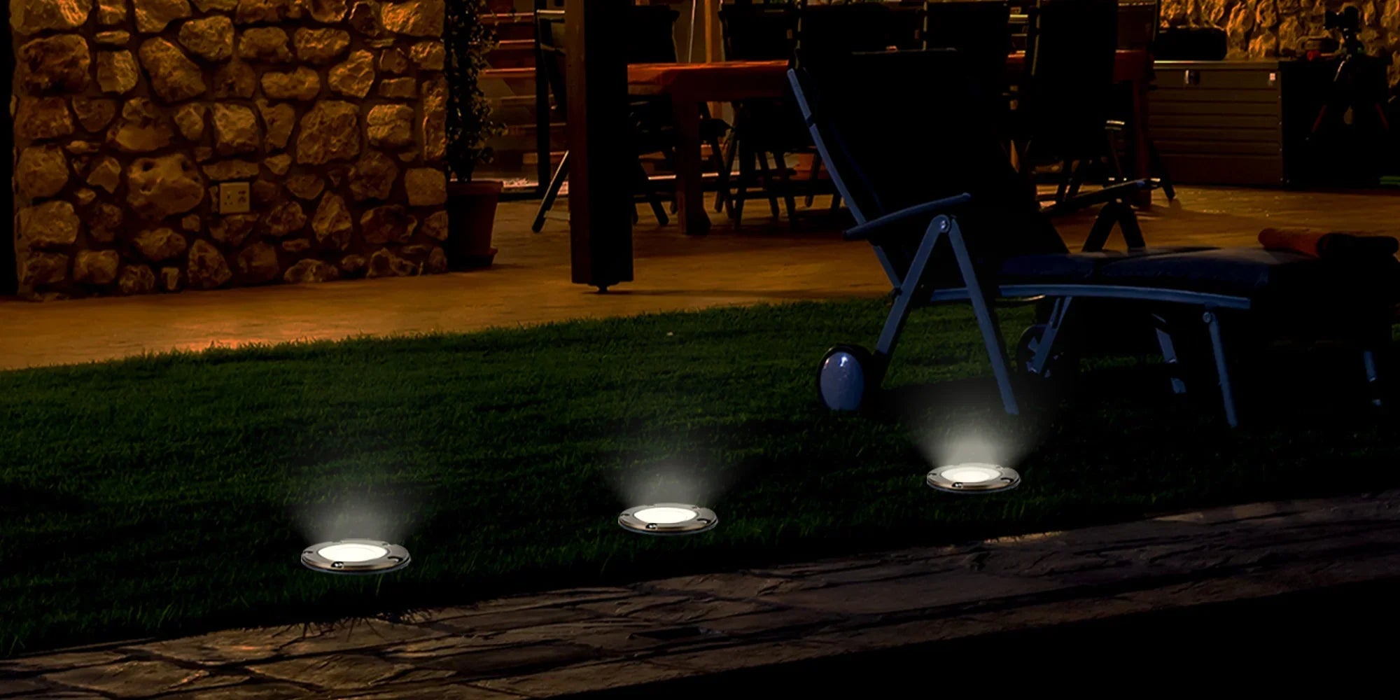 LED outdoor wall lighting illuminating garden path and patio seating at night